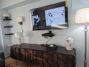 a flat screen tv sitting on top of a wooden entertainment center at Fully renovated Manhattan gem in New York