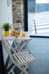 a picnic table with orange juice and donuts and a chair at El Estudio de La Artista - El casar de Leo in Alburquerque