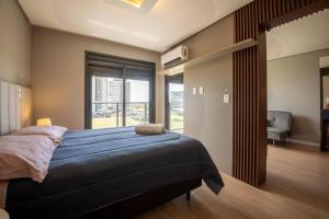 a bedroom with a bed and a large window at Apto 617 com vista Parque Una in Pelotas