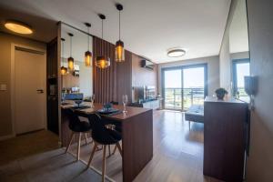 a room with a kitchen with a bar and chairs at Apto 617 com vista Parque Una in Pelotas