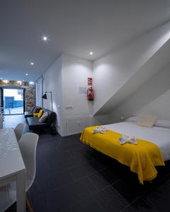 a bedroom with a bed with a yellow blanket at El Estudio de La Artista - El casar de Leo in Alburquerque