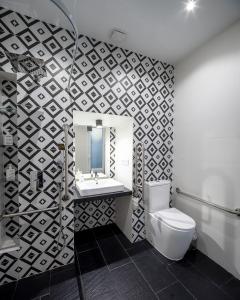 a bathroom with a toilet and a sink and a mirror at El Estudio de La Artista - El casar de Leo in Alburquerque