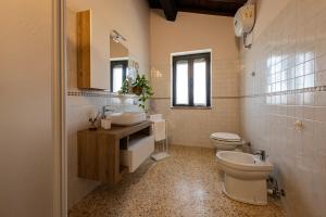 a bathroom with a toilet and a sink and a mirror at Il casale del Mignone in Blera