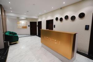 a lobby with a green couch and plates on the wall at BALAND HOTEL DUSHANBE in Dushanbe