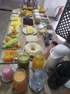 una mesa larga con diferentes tipos de comida en Pousada Castelo do Rei en Penha