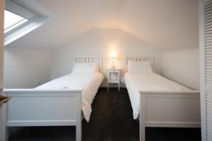 Duas camas brancas num quarto com uma janela em The Prestwick Pad em Prestwick