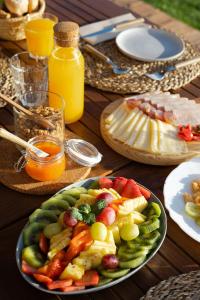 a wooden table with a plate of food and juice at Monte do Cerro in Porto Covo
