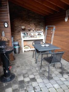 Lierneux的住宿－Le fournil，庭院配有桌椅和炉灶。