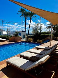 - une piscine avec chaises longues à côté de la piscine dans l'établissement Botanico Beauty Villa del Mar, à Jávea
