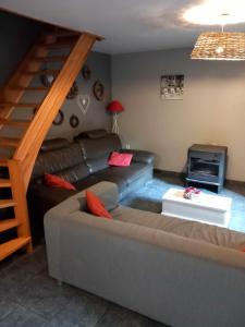 Lierneux的住宿－Le fournil，带沙发和楼梯的客厅