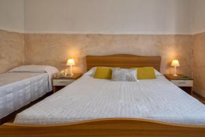 1 dormitorio con 2 camas y 2 lámparas en las mesas en Casa Vacanza Baratz 1, en Alghero