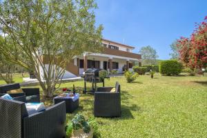 un patio con sillas y mesas frente a una casa en Casa Vacanza Baratz 1, en Alghero