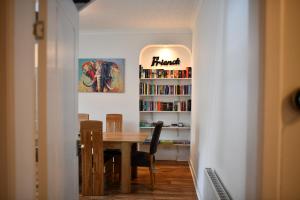 a dining room with a table and a book shelf at The Prestwick Pad in Prestwick