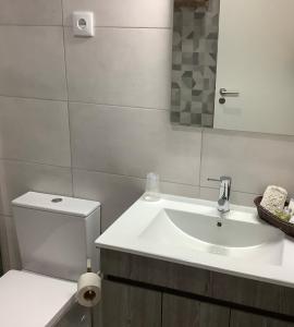 une salle de bain avec un lavabo, des toilettes et un miroir dans l'établissement Casa da Moagem, à Vinhais