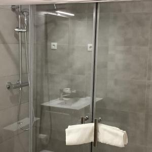 une salle de bain avec une douche avec un lavabo et un miroir dans l'établissement Casa da Moagem, à Vinhais