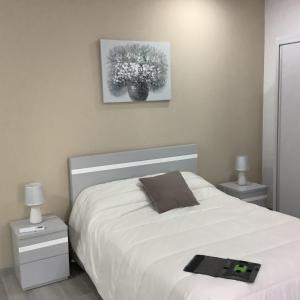 Un dormitorio con una cama blanca y una foto en la pared en Casa da Moagem, en Vinhais