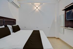 a bedroom with a large bed with a ceiling fan at Hotel O RR Palace in Bheta