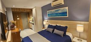 a bedroom with a bed with blue sheets and pillows at Option Full Service Residence in Rio de Janeiro