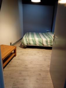L'orée des 3 Rivières في إيس سور تيل: غرفة نوم بسرير وطاولة خشبية