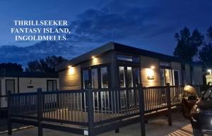 a tiny house in a parking lot at night at Thrillseeker - Chalet style caravan next to Fantasy Island, Ingoldmells, 2 dogs max - East Coast Holidays in Skegness +20 photos
