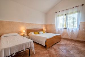 a bedroom with two beds and a window at Casa Vacanza Baratz 2 in Alghero