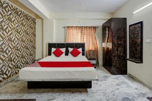 ラーンチーにあるOYO Flagship Hotel Luxury Innのベッドルーム1室(大型ベッド1台、赤い枕付)