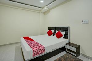 ラーンチーにあるOYO Flagship Hotel Luxury Innのベッドルーム1室(赤い枕のベッド1台付)