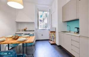 une cuisine avec des placards blancs et une table en bois dans l'établissement 2 Bedroom Cozy Apartment In Genova, à Gênes