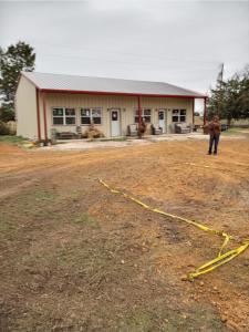 a man standing in a field in front of a building at Tmae's Bed & Rest in Edgewood