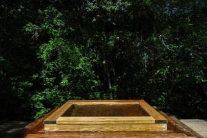 una scatola di legno seduta di fronte ad alcuni alberi di 奥武雄温泉　風の森 a Ureshino