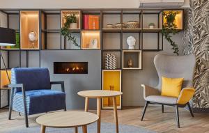 a living room with chairs and a fireplace at Appart'hôtel Odalys City - Nîmes Arènes - Palais des Congrès in Nîmes
