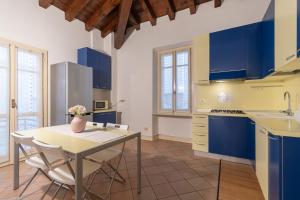una cucina con armadi blu, tavolo e sedie di Appartamento Filippo 26 F&L Apartment a Brescia