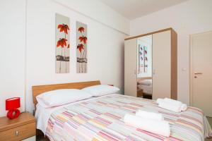 una camera bianca con letto e specchio di Apartment with private swimming pool a Podstrana