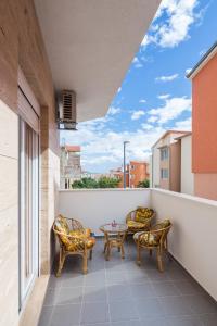 Un balcón con sillas y una mesa con vistas. en Apartment with private swimming pool, en Podstrana