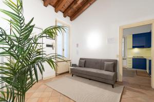 un soggiorno con divano e pianta di Appartamento Filippo 26 F&L Apartment a Brescia