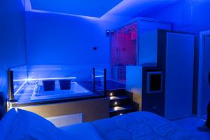 een blauwe kamer met een bed en een trap bij AETERNA SUITES SPA Apartment in Terracina