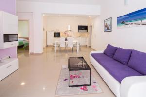sala de estar con sofá púrpura y mesa en Apartment Kolar, en Podstrana