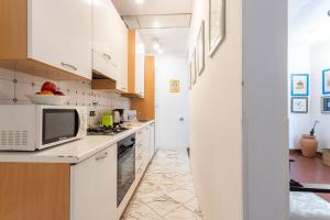 uma cozinha com armários brancos e um micro-ondas em Canottieri em Florença
