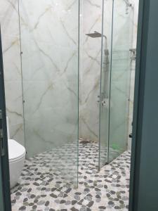 a glass shower in a bathroom with a toilet at Romantic house with garden in Bien Hoa in Bùi Tiếng