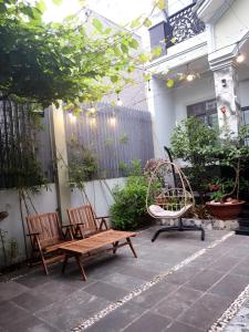 - 2 chaises et un banc sur la terrasse dans l'établissement Romantic house with garden in Bien Hoa, à Bùi Tiếng