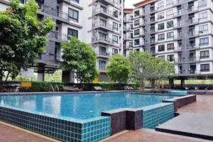 a swimming pool in front of some tall buildings at Living avenue condo in Ban Rong Khoei