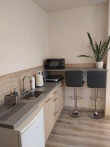 a kitchen with a sink and two bar stools at Studio near Old Town in Krakow