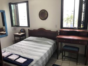 a bedroom with a bed and a desk and windows at Riviera: M4 Giardino 44A, frente Praia, 4Dorms, 3Banh, 2Gar, Varanda Gourmet com Churrasqueira in Riviera de São Lourenço