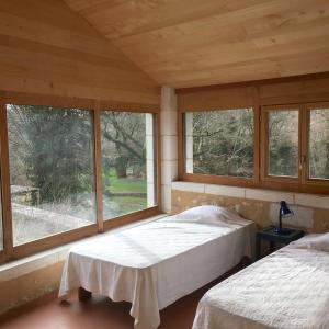 two beds in a room with two windows at Hameau de la Brousse in Sers