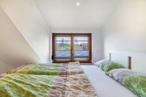 two beds in a room with a window at Ferienhaus Landliebe in Ötisheim