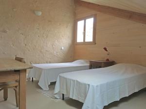 a room with two beds and a window at Hameau de la Brousse in Sers