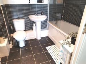a bathroom with a toilet and a sink and a tub at Stylish flat in London, Canary Wharf in London