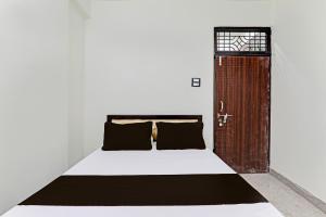 een slaapkamer met een bed en een houten deur bij OYO Flagship HOTEL NEW in Prayagraj