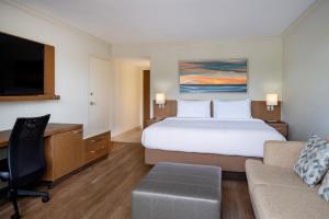 a hotel room with a bed and a desk at Courtyard by Marriott - Naples in Naples