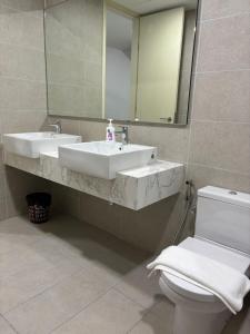 een badkamer met een wastafel, een toilet en een spiegel bij The Ooak Suites, Kiara 163 by Bamboo Hospitality in Kuala Lumpur